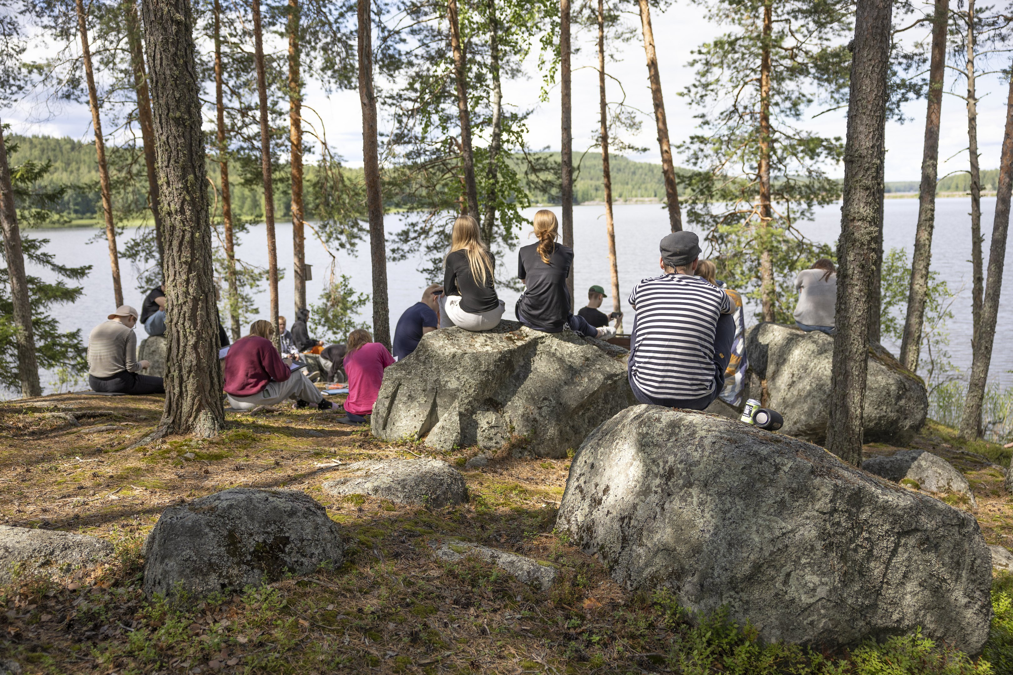 Nuoret istumassa metsässä.